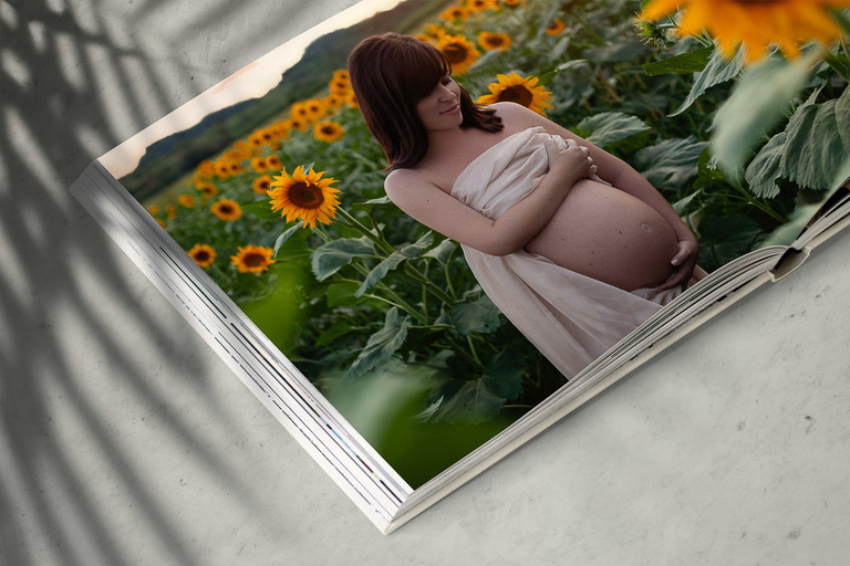 album fotografico con ritratto di donna incinta al tramonto in un campo di girasoli
